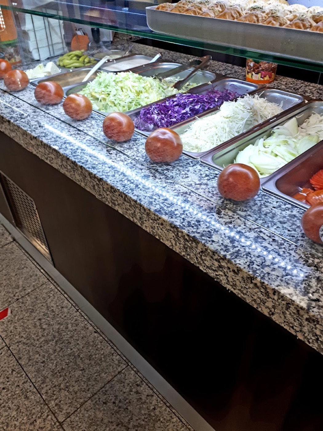 Frische Zutaten wie Tomaten, Weißkohl und Salat an der Theke bei City Grill Göppingen
