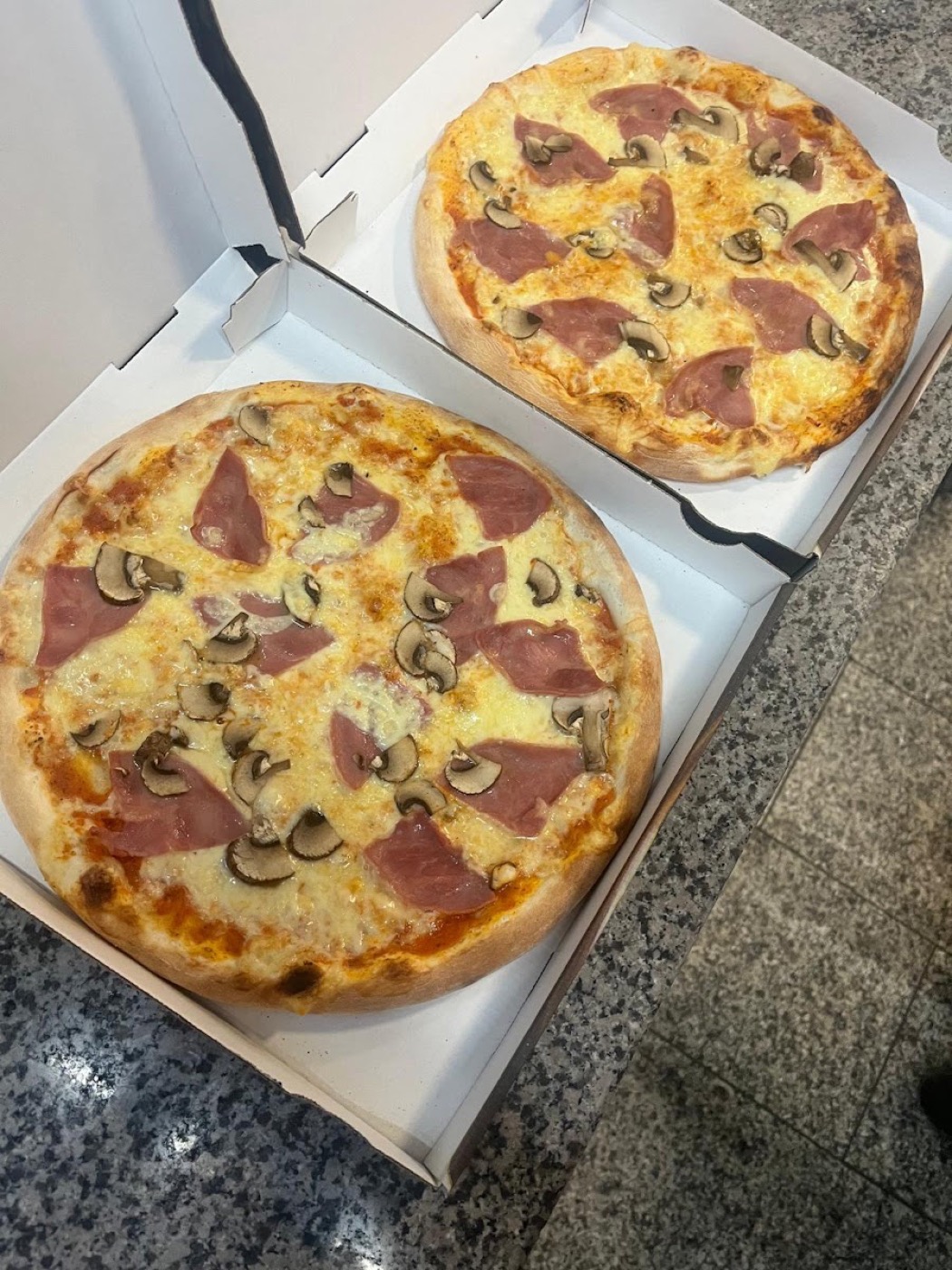 Frisch gebackene Pizza mit Schinken und Champignons bei City Grill Göppingen
